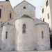 La parte retrostante della chiesa  adagiata sulla frequentatissima piazza del Ferrarese. Fanno bella mostra di s la testata con timpano triangolare forata al centro da una finestrella circolare e le tre absidi, due laterali e una centrale, tutte interrotte da monofore